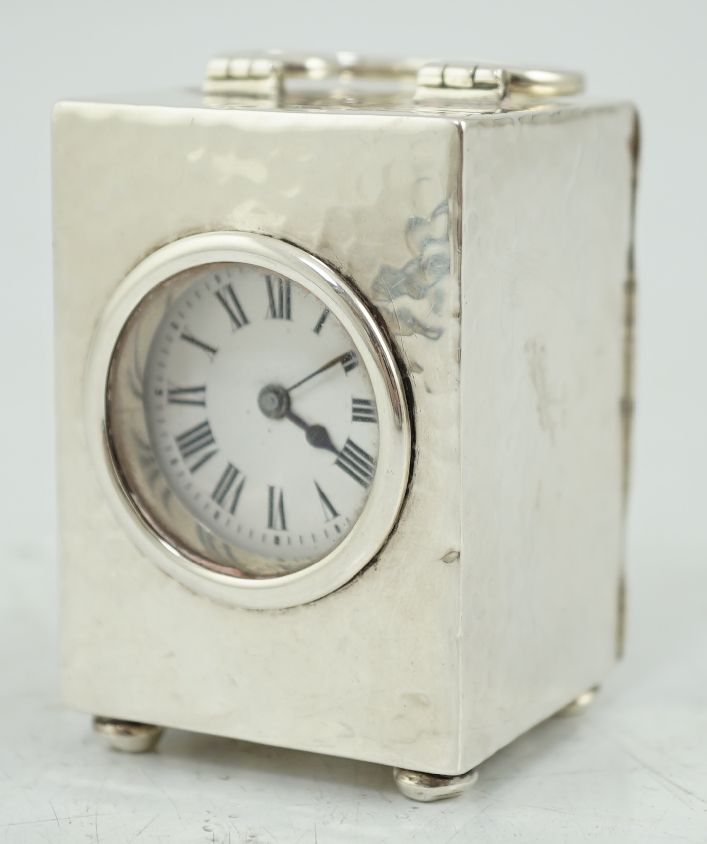 An Edwardian planished silver miniature carriage timepiece, by Arthur Baume & Co